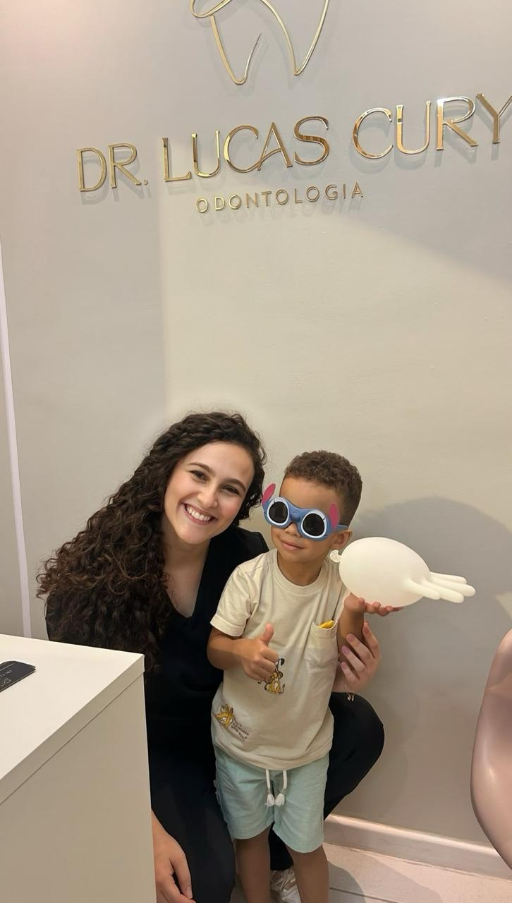 Dra. Maria Tereza com uma criança no consultório.